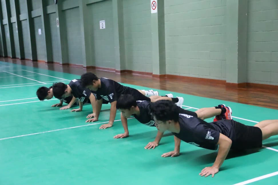 Students learning badminton technique at Shuttle Force Badminton Club