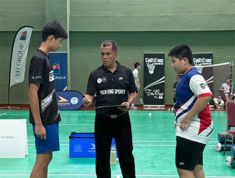 Badminton coach guiding students during training